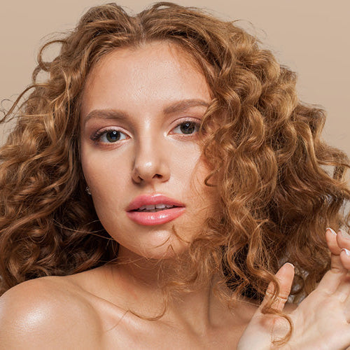 A woman with auburn, curly hair