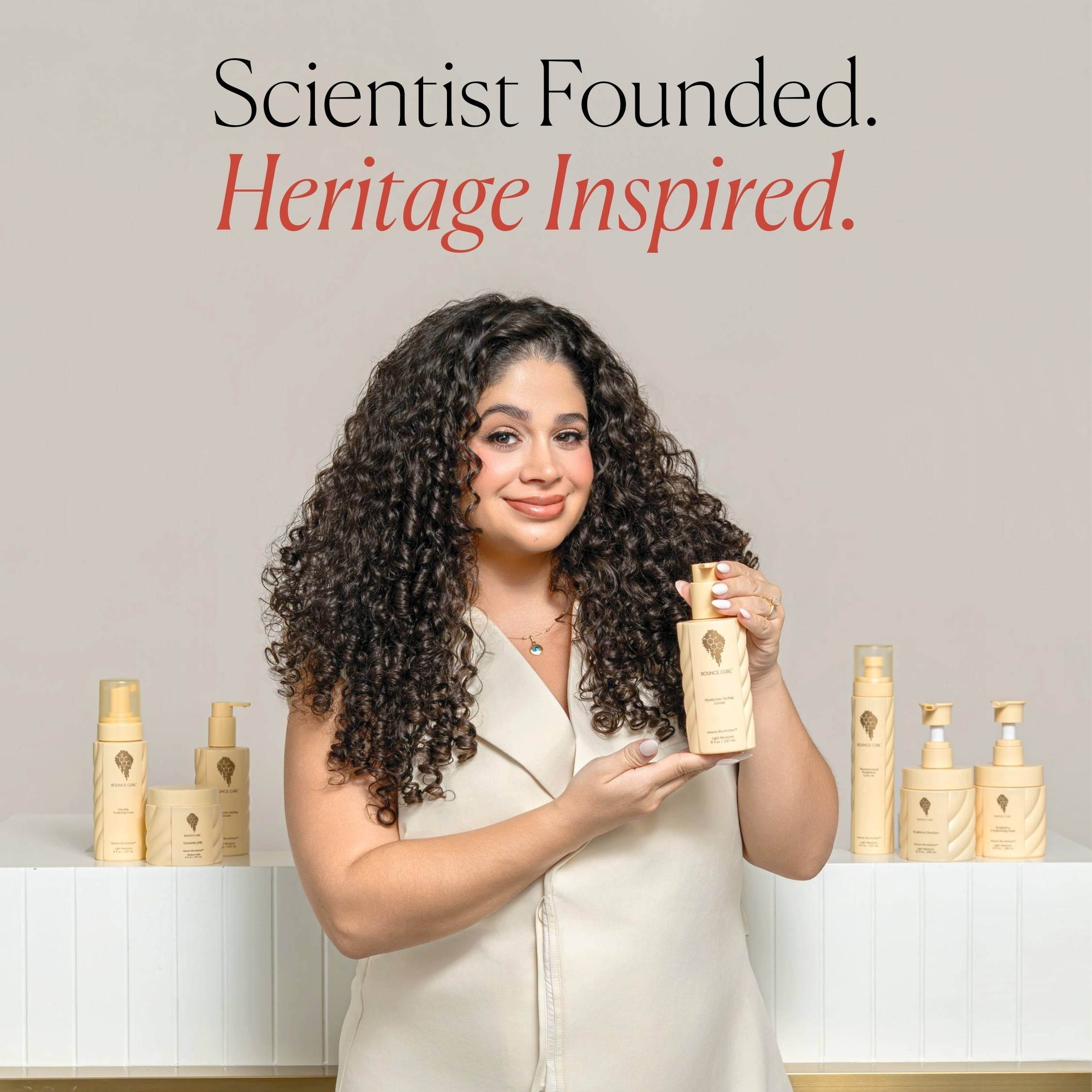 Woman holding a bottle of hair care product with text 'Scientist Founded. Heritage Inspired.'
