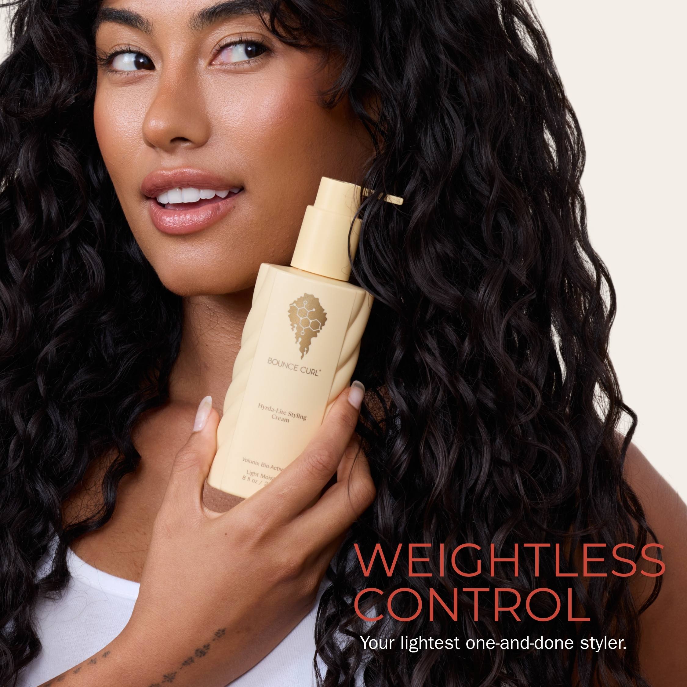 Woman holding a bottle of hair product with 'Weightless Control' text on a plain background