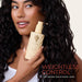 Woman holding a bottle of hair product with 'Weightless Control' text on a plain background