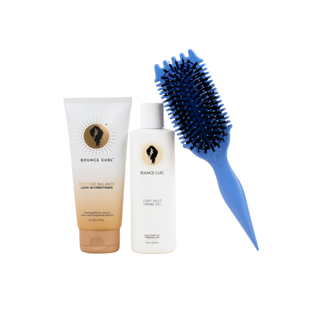 Bounce Curl hair care products including a tube, bottle, and blue brush on a white background