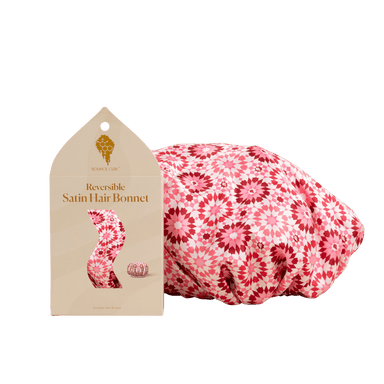 Reversible satin hair bonnet with packaging on a green background