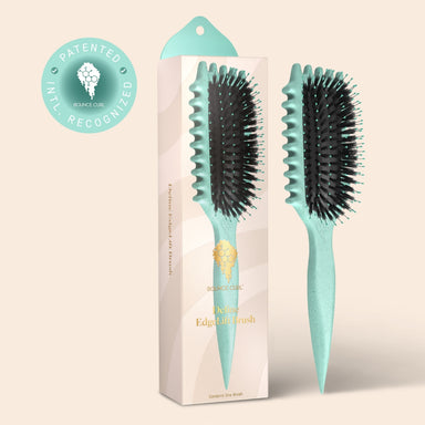 Teal hairbrush with black bristles next to its packaging on a beige background